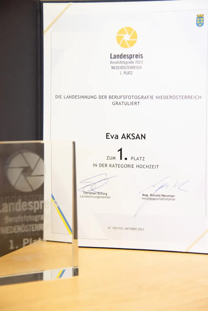 Urkunde Landespreis Berufsfotografie 2023 Niederösterreich für Eva Aksan, davor gläserne Trophäe