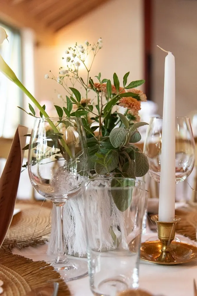 Tafel in der La Crêperie mit Kerze und Wildblumen in Glasvasen