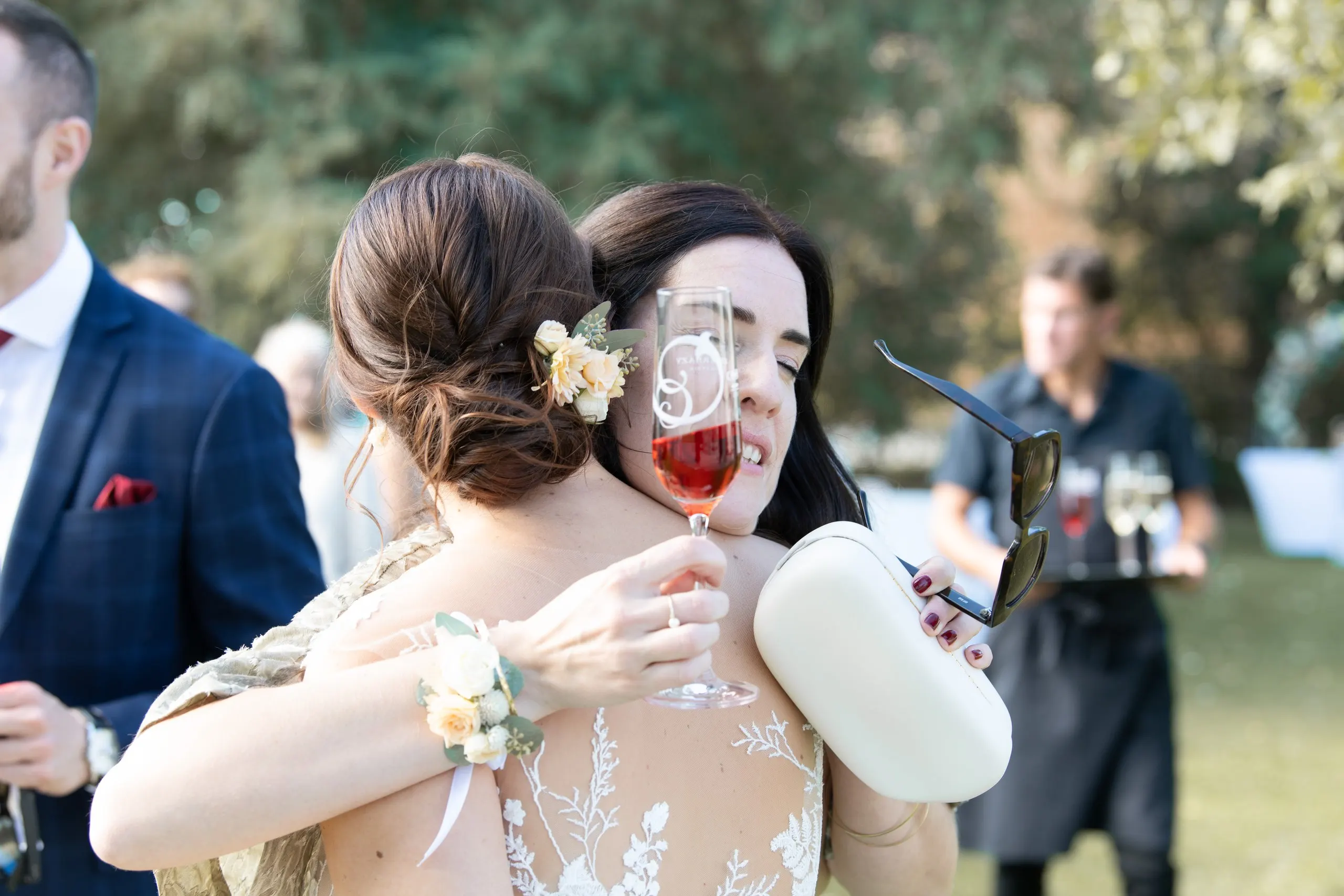 Eine Gästin umarmt Anja innig bei der Gratulation, das Sektglas noch in der Hand