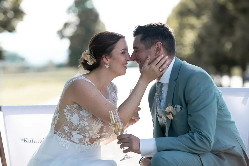 Anja hält Martins Gesicht in den Händen, beide sitzen im Garten