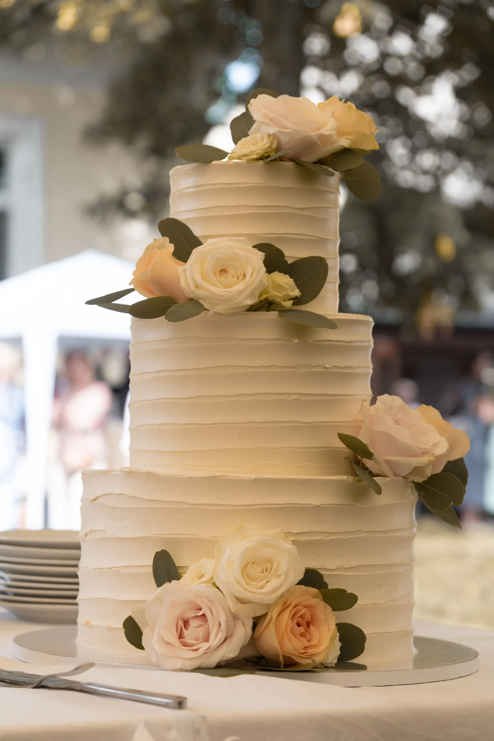 Dreistöckige Hochzeitstorte mit Rillenmuster und Rosen
