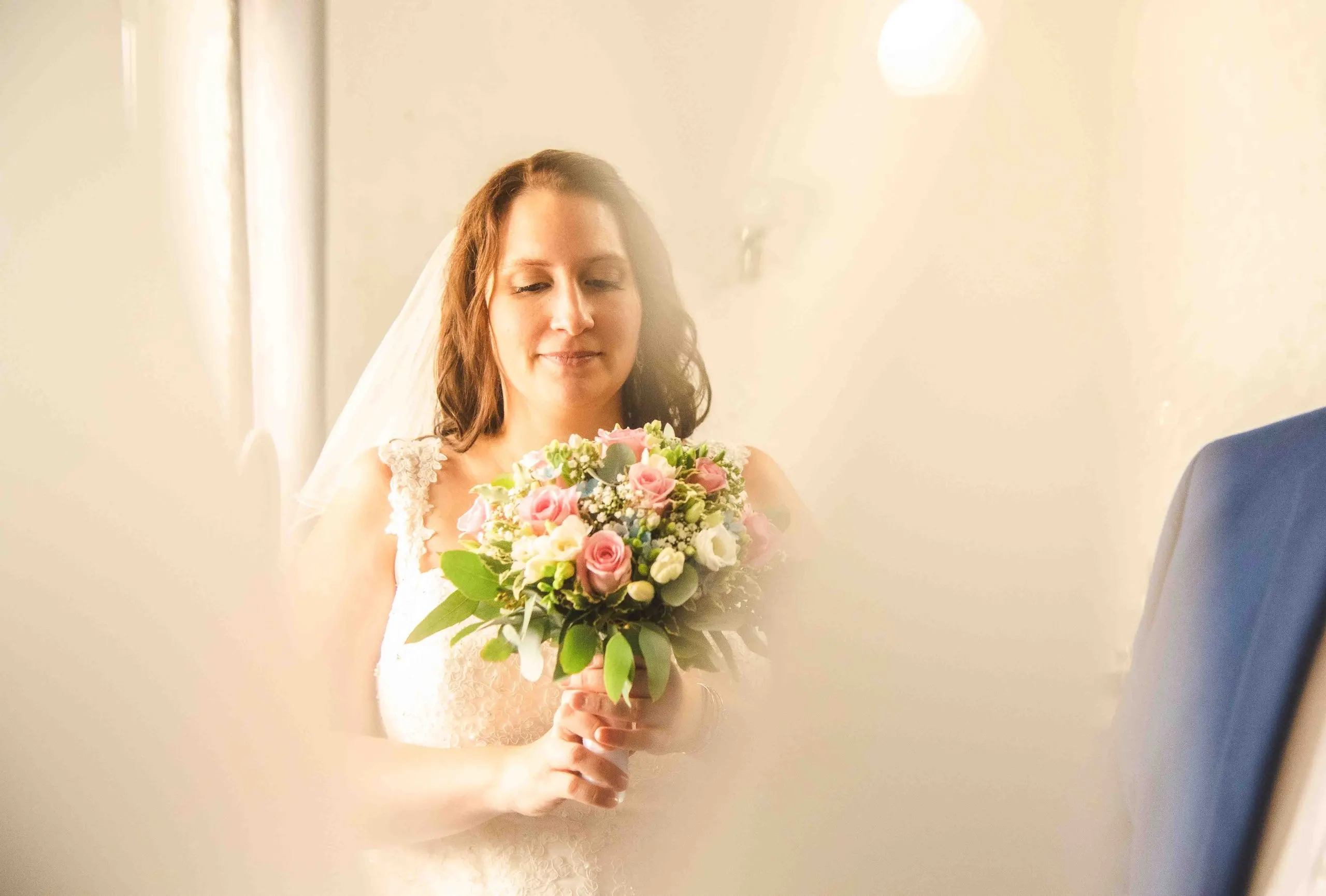 Die Braut mit Rosenstrauß im weichen Gegenlicht