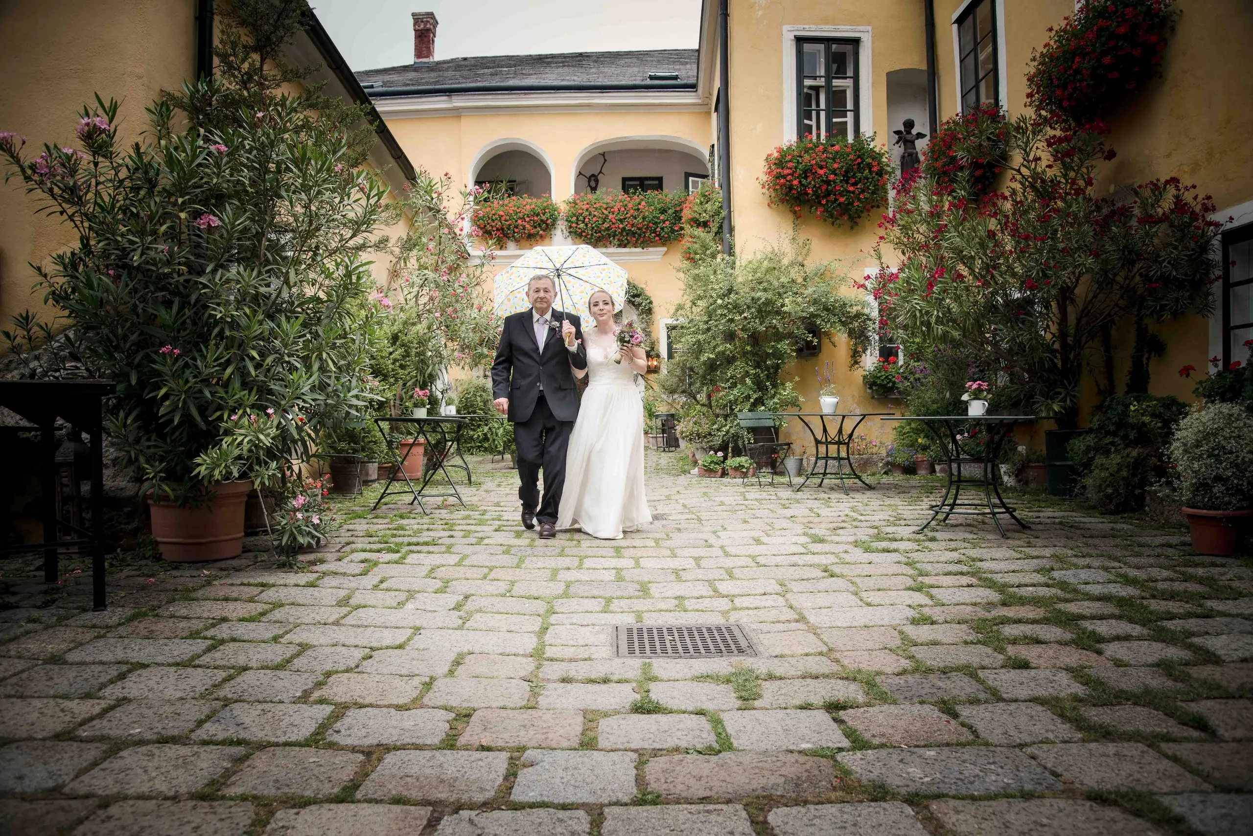 Das Brautpaar im gepflasterten Innenhof des Melkerhofs