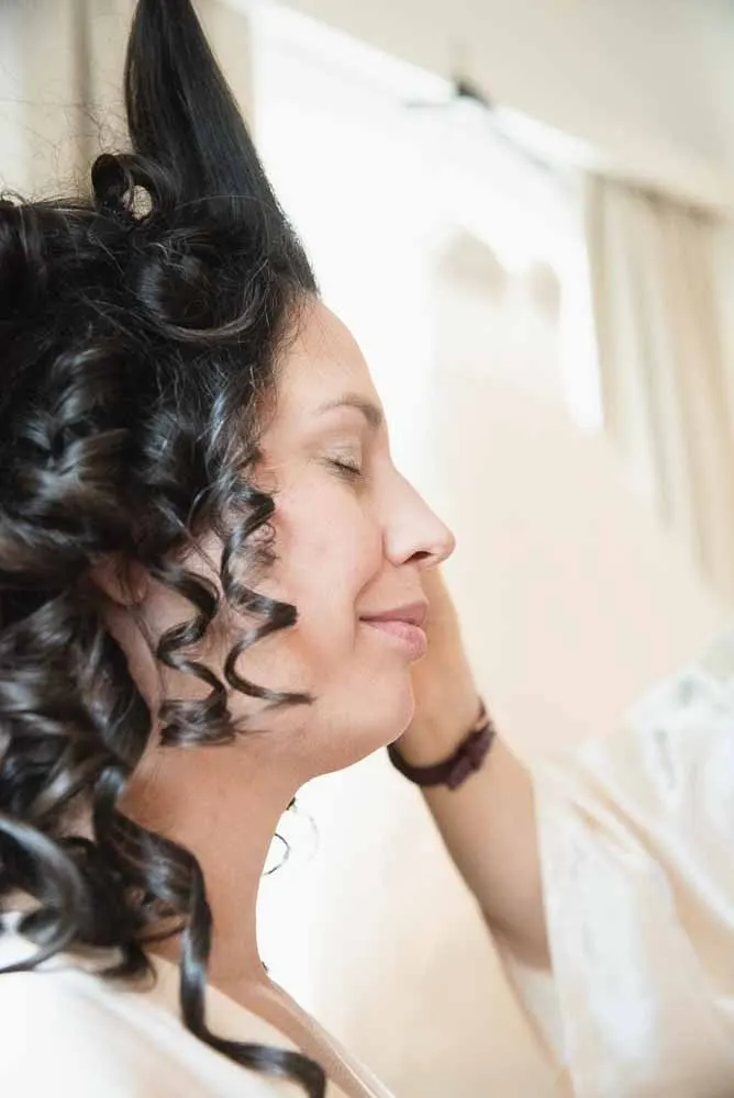 Beim Make-up: Die Braut mit dunklen Locken schließt die Augen