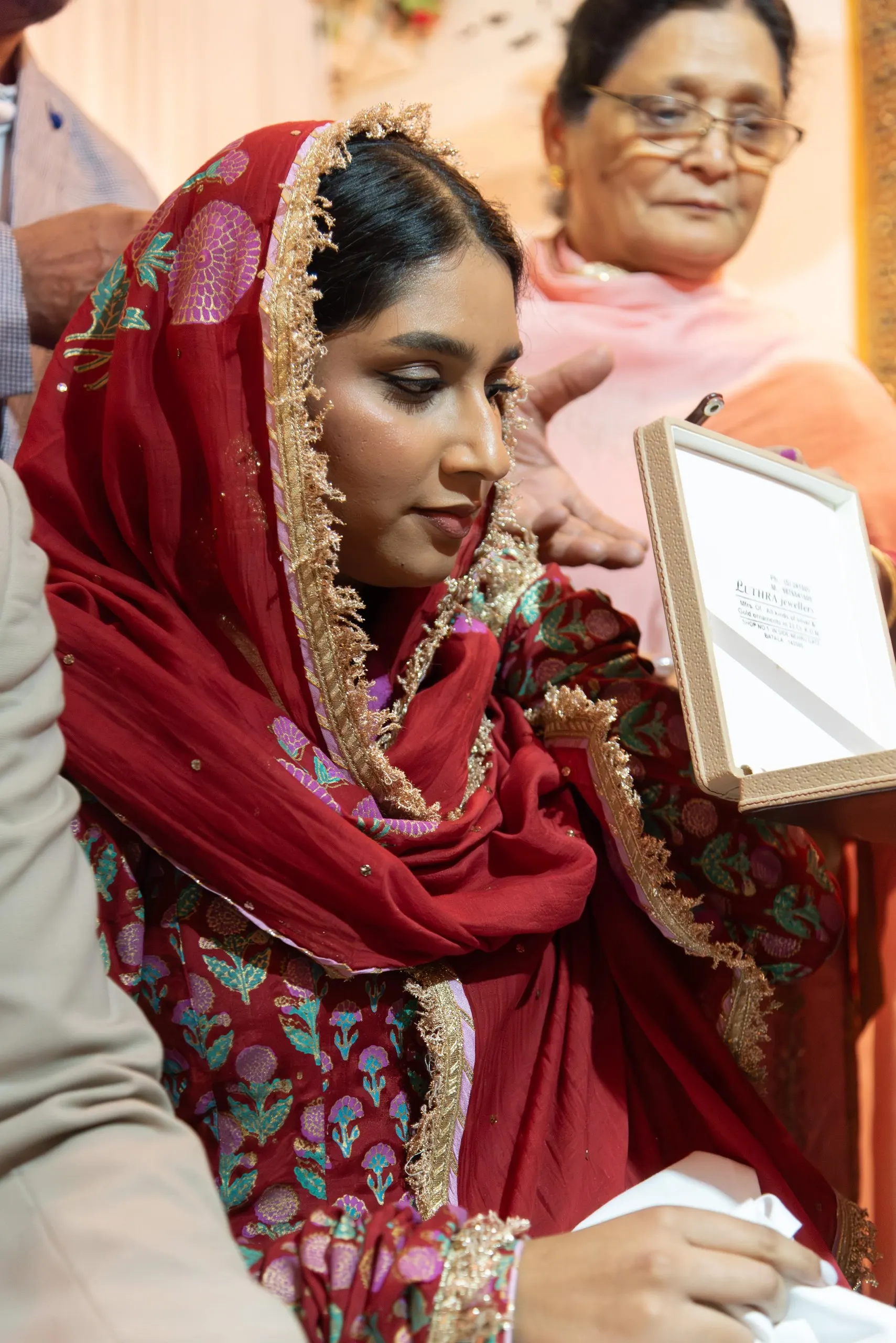 Sie in rotem, goldbesticktem Dupatta lächelt