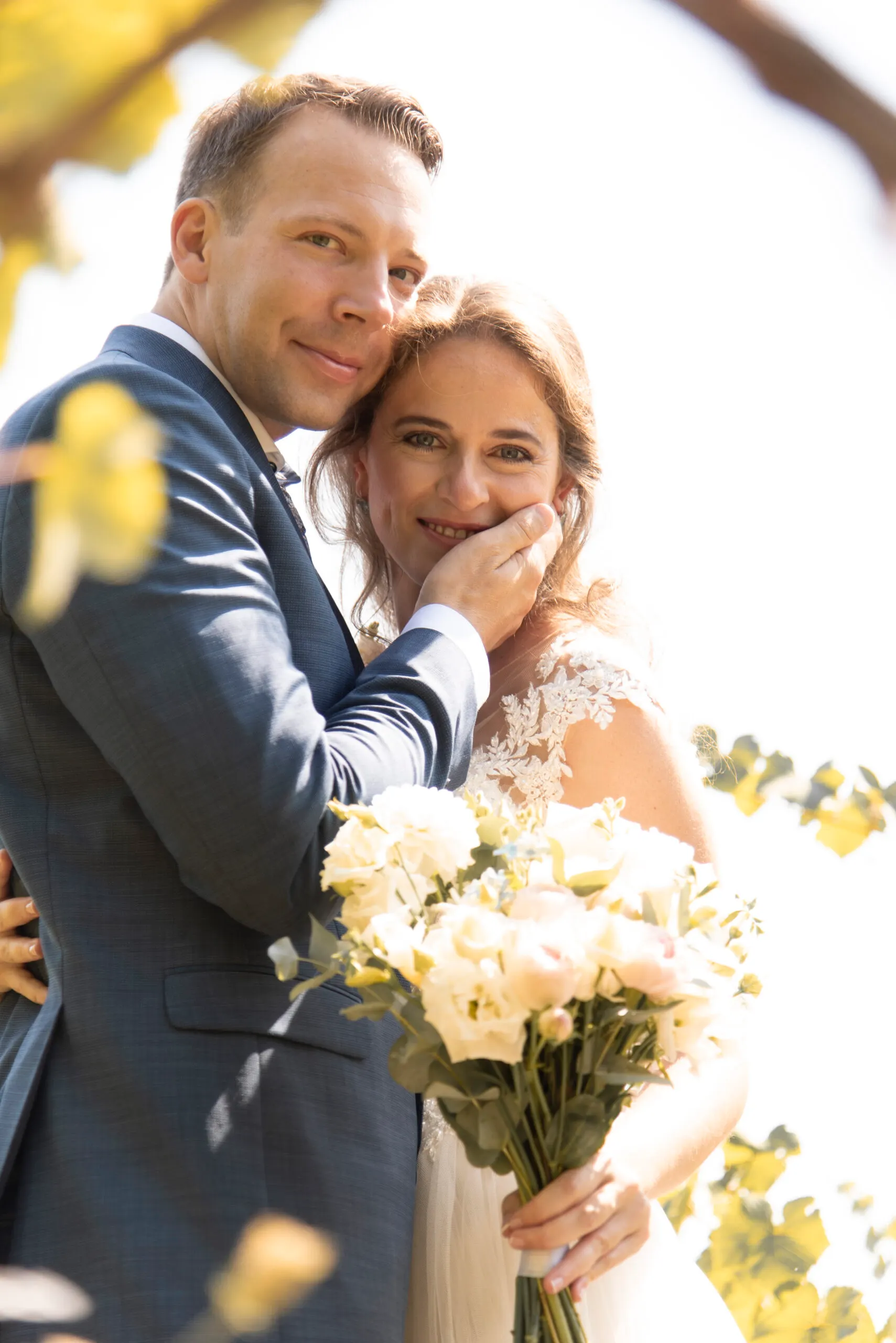 Sandor legt die Hand an Karens Wange, sie hält den Strauß aus cremefarbenen Rosen