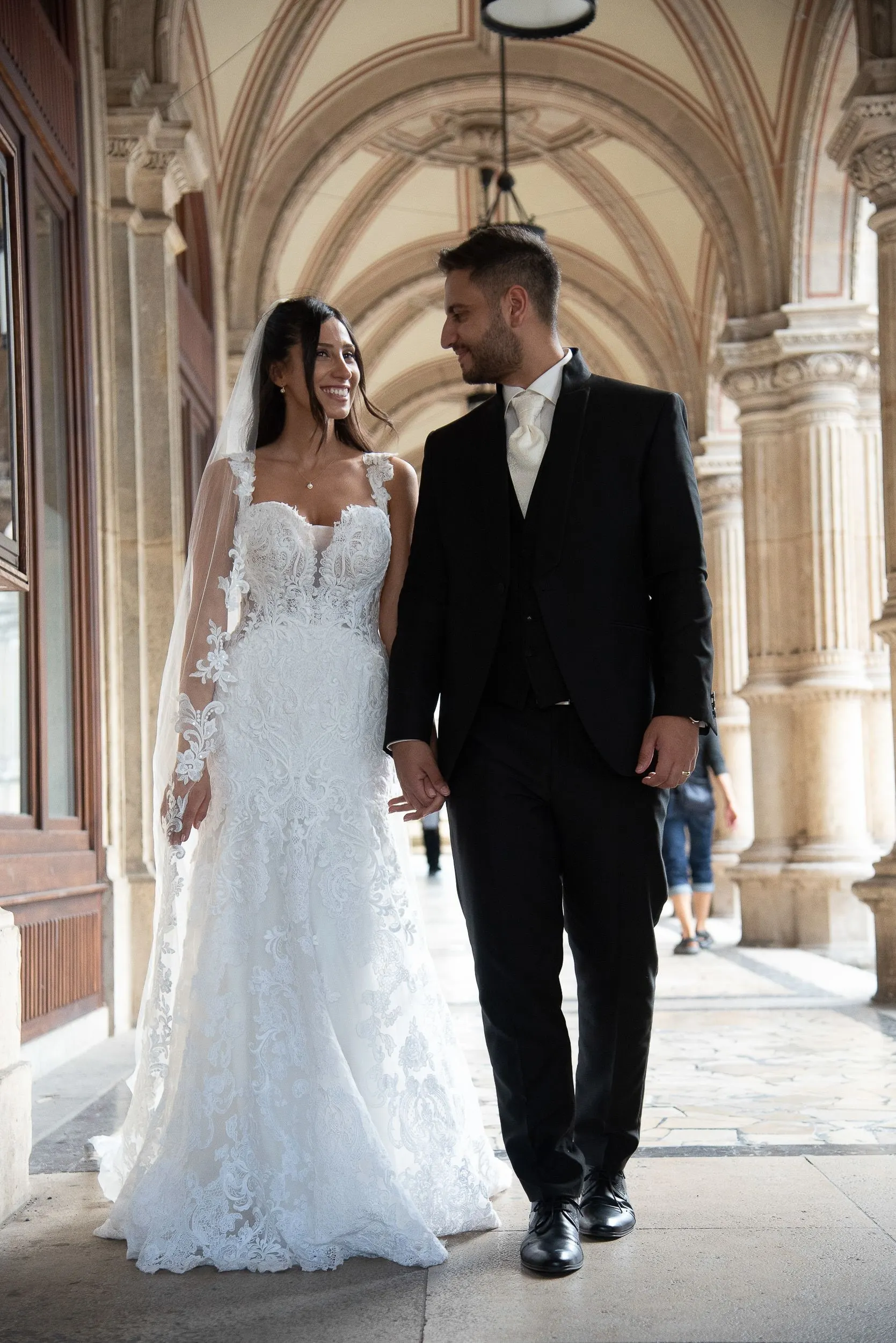 Hand in Hand gehen Melissa und Benjamin durch den Arkadengang